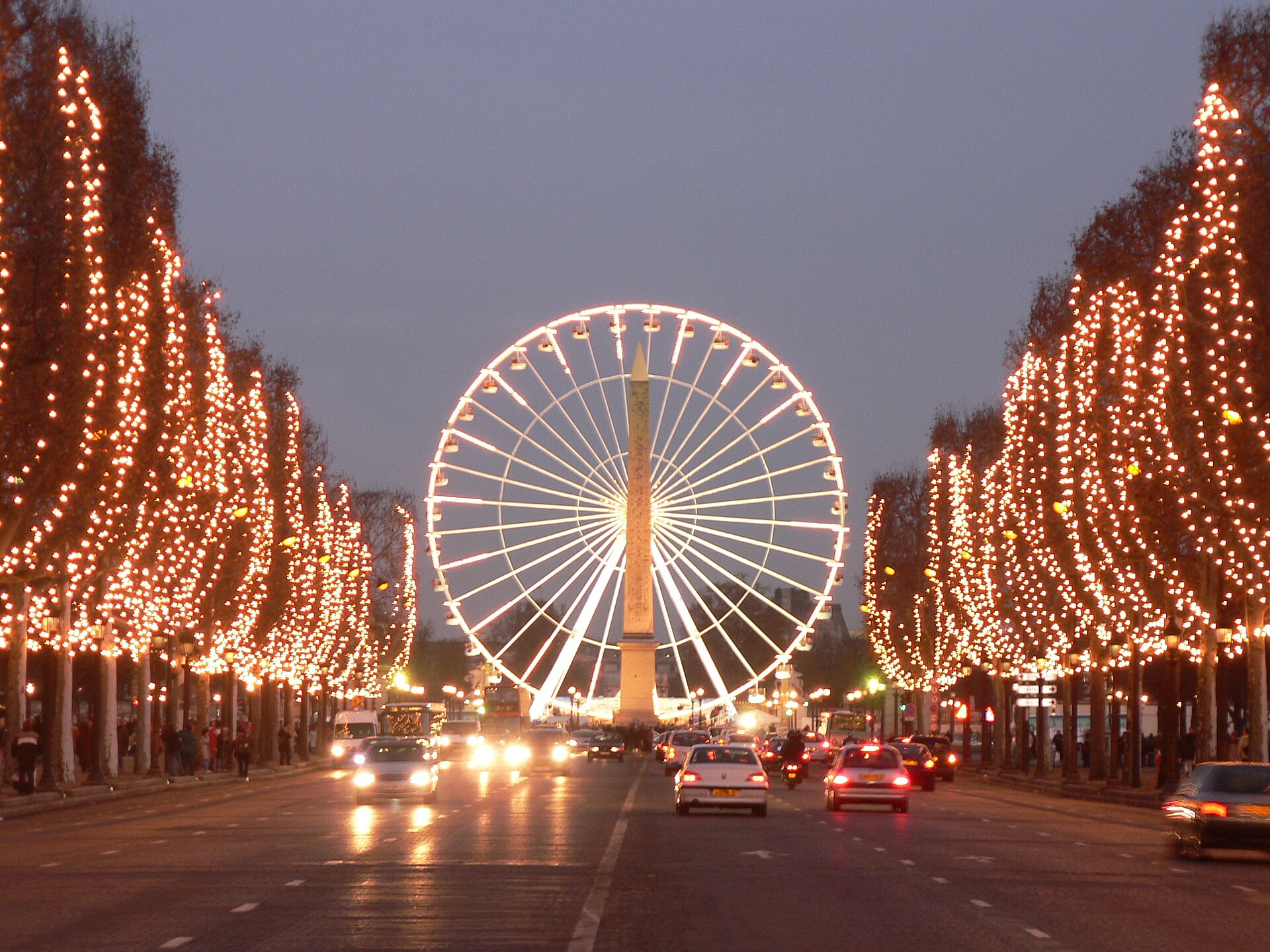 L'avenue des Champs-Élysées à Paris sous ses illuminations de Noël, avec la grande roue de la place de la Concorde au fond