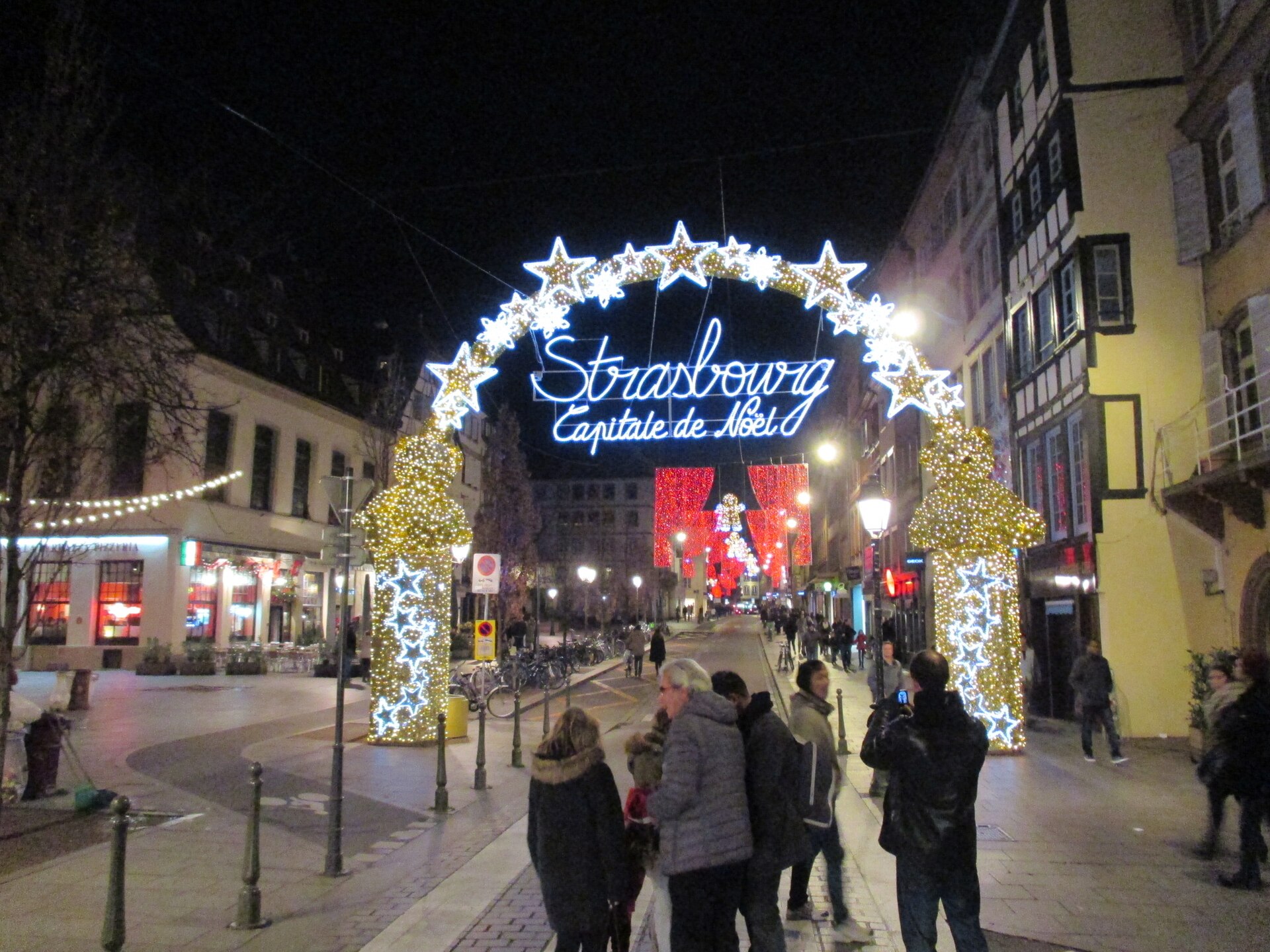 L'arche lumineuse « Strasbourg, Capitale de Noël » dans une rue du centre, à la tombée de la nuit
