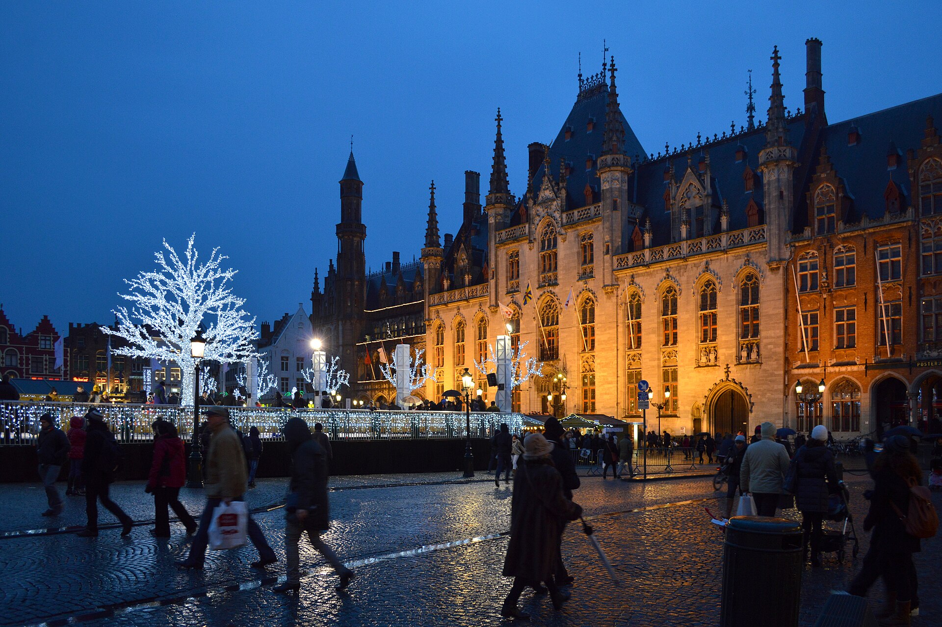 La Grand-Place de Bruges (Markt) à la tombée de la nuit, avec le palais provincial éclairé et un arbre de lumière